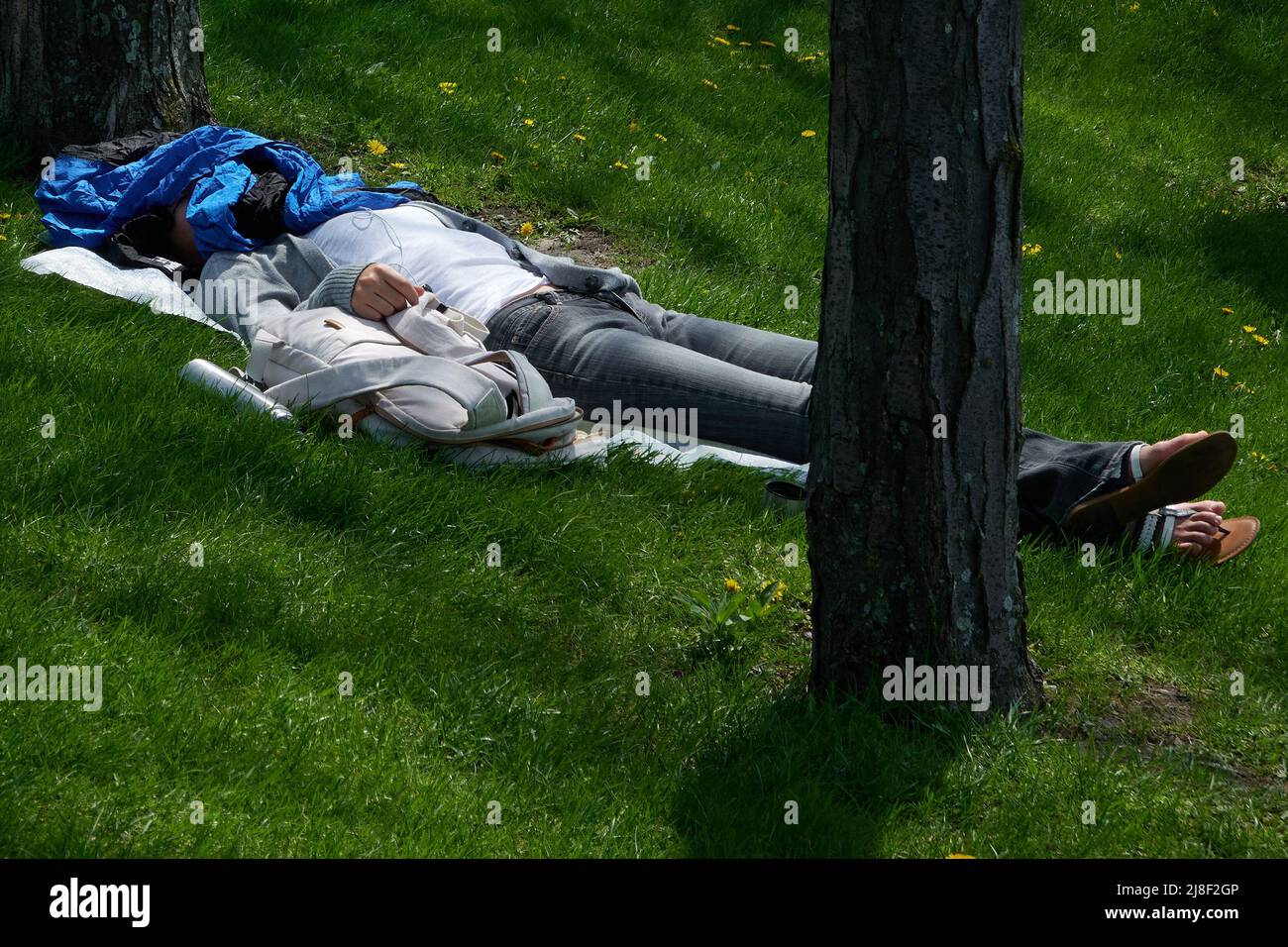 woman lying in the Chicago park resting on a warm day Stock Photo