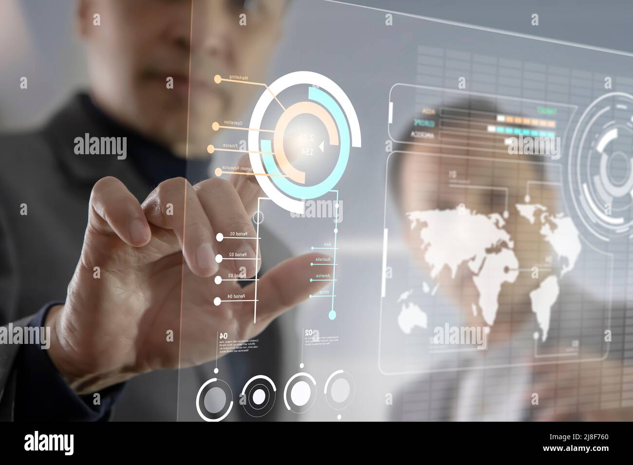 Two Asian businessmen interacting with futuristic virtual touchscreen while analysing business information data Stock Photo