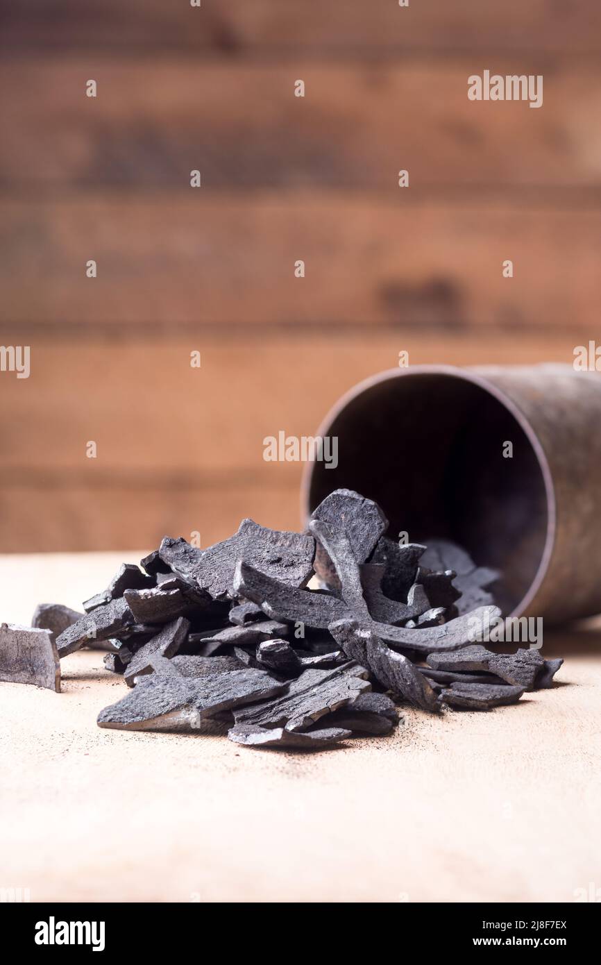 coconut shell charcoal scattered on table top from a container, carbonized raw shells in a limited supply of air Stock Photo