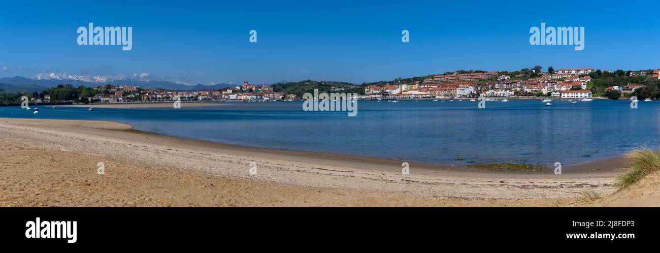 San Vicente de la Barquera, Spain - 25 April, 2022: panorama view of Maza Beach and San Vicente de la Barquera with Picos de Europa mountains in the b Stock Photo