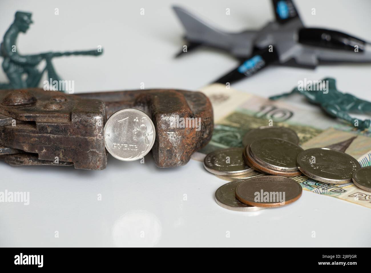 The gas key holds one Russian ruble and next to it is a children's toy army of soldiers and an airplane, sanctions against Russia, the collapse of the Stock Photo