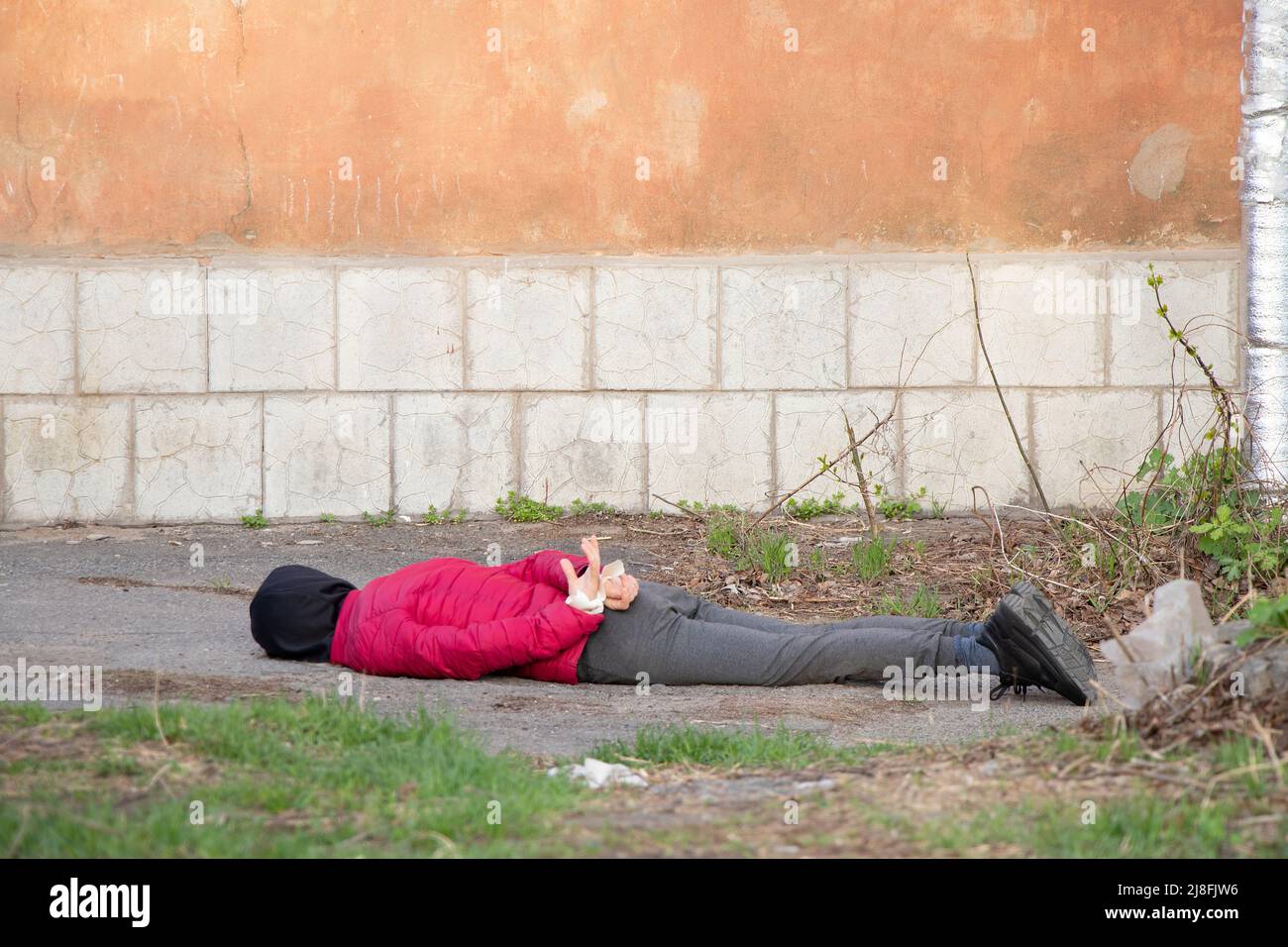 A dead Ukrainian woman lies on the street with her hands tied with a white rope and was killed in the back in Ukraine, a death protest in the city of Stock Photo