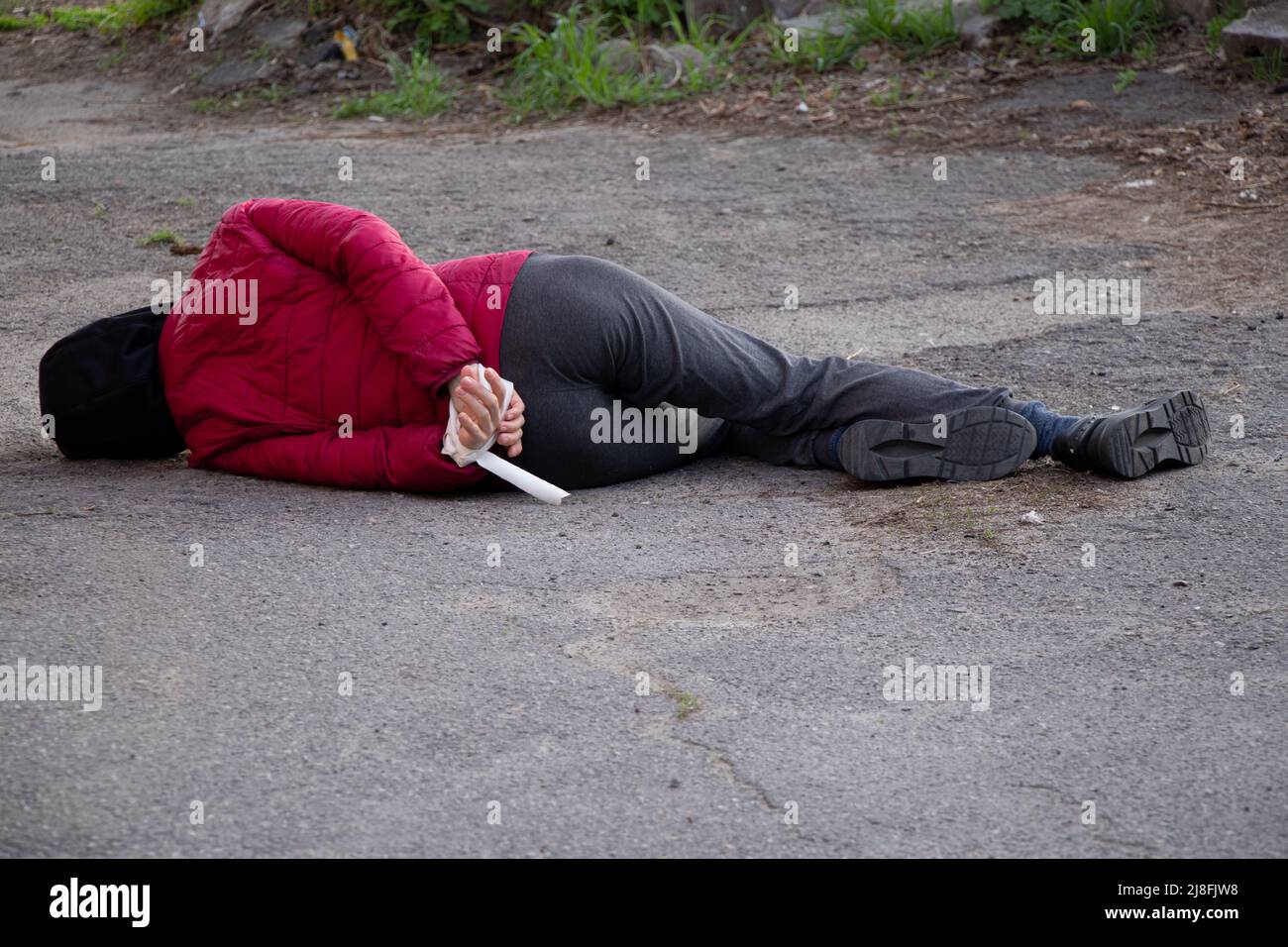 A dead Ukrainian woman lies on the street with her hands tied with a white rope and was killed in the back in Ukraine, a death protest in the city of Stock Photo