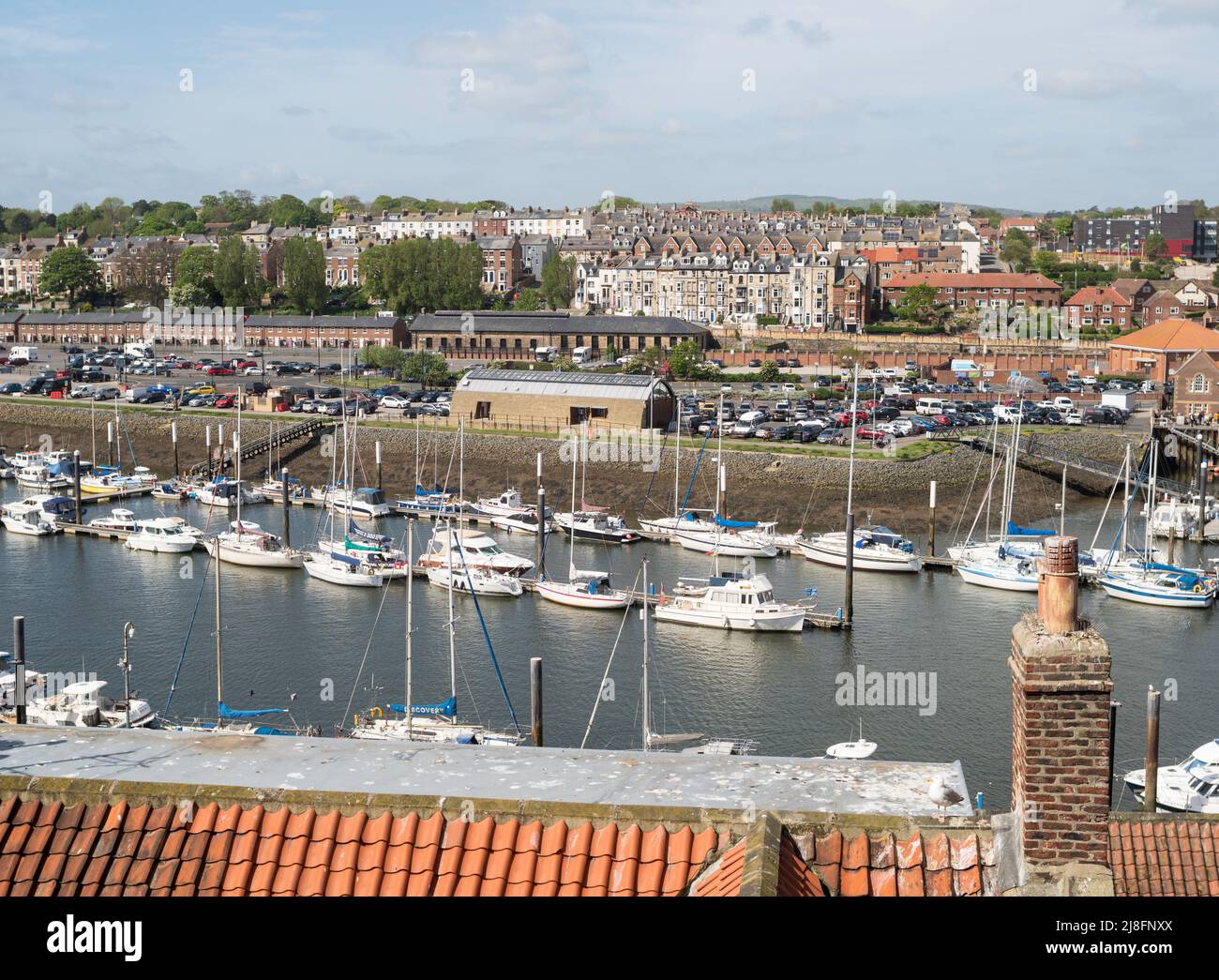 A view across the river Esk in Whitby showing boats moored in the river, Yorkshire, England Stock Photo