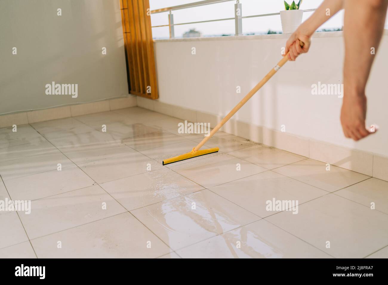 Man wiping floor with the mop. Janitor washing the dirty floors. Guy