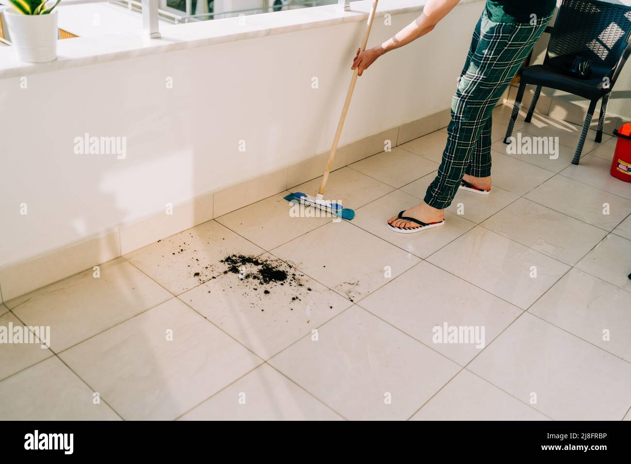 Man wiping floor with the mop. Janitor washing the dirty floors. Guy