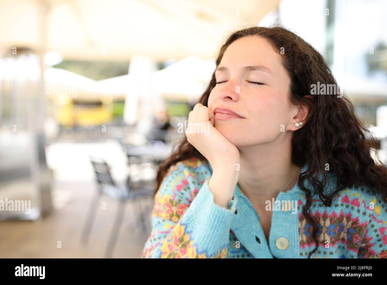 Relaxed woman sitting in a bar resting with closed eyes Stock Photo - Alamy