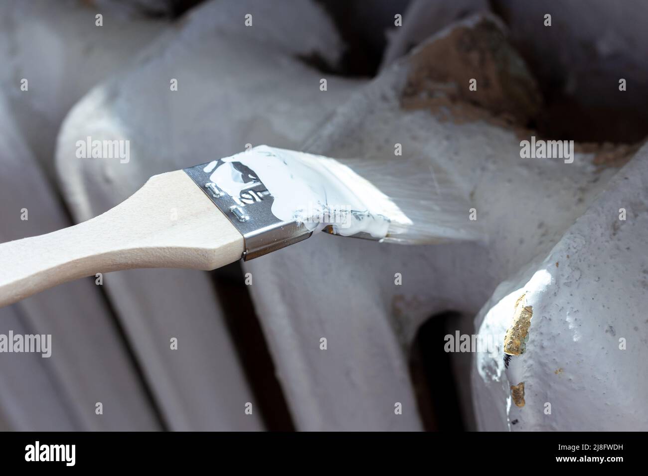 Painting radiators with a special brush. Battery painting Stock Photo