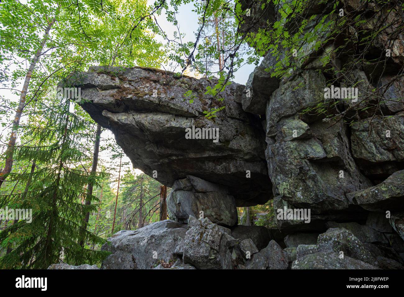 Famous cave and cliff in a lush forest at the Pirunvuori ('Devil's Mountain') on a sunny morning at summer in Sastamala, Southern Finland. Stock Photo