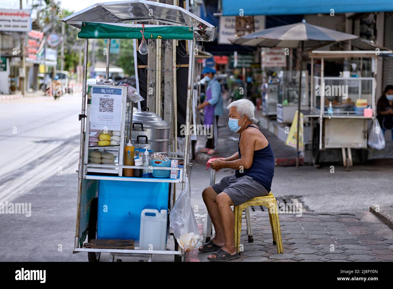 Senior working. Thailand street vendor. Elderly man selling food on the sidewalk. Thailand Southeast Asia Stock Photo