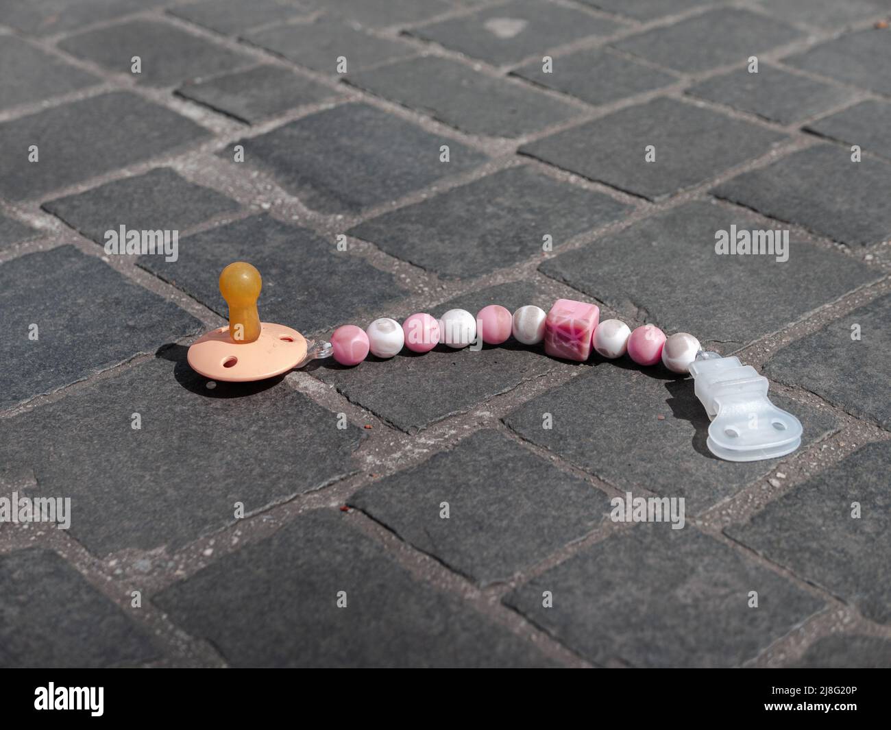The lost baby dummy lies on the sidewalk Stock Photo