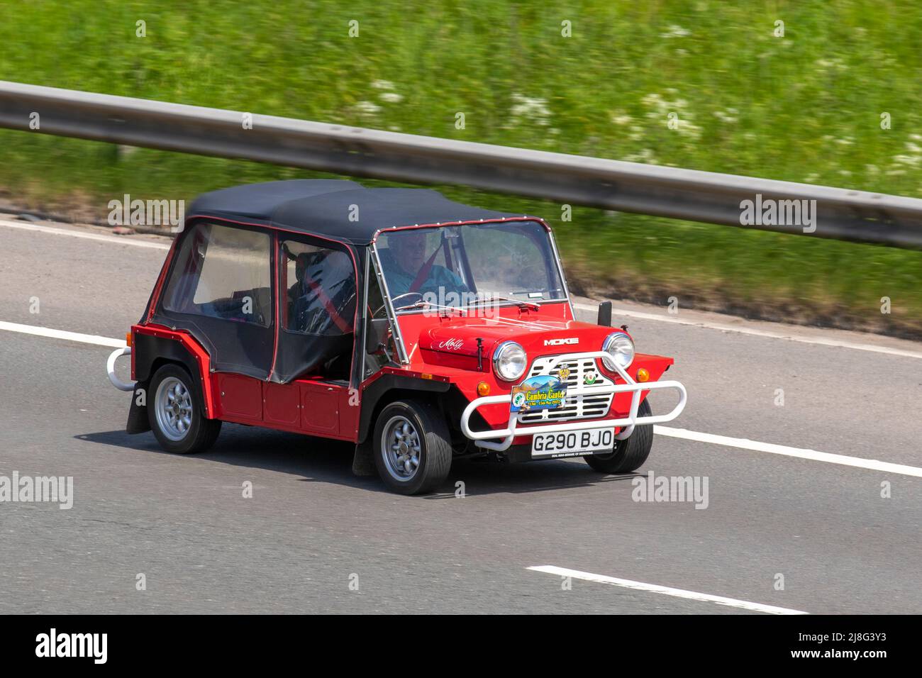 'Molly' 1989 80s red eighties Austin Mini Moke MT 15-18 988cc Petrol canvas concept car being driven on the M6 Motorway, UK Stock Photo