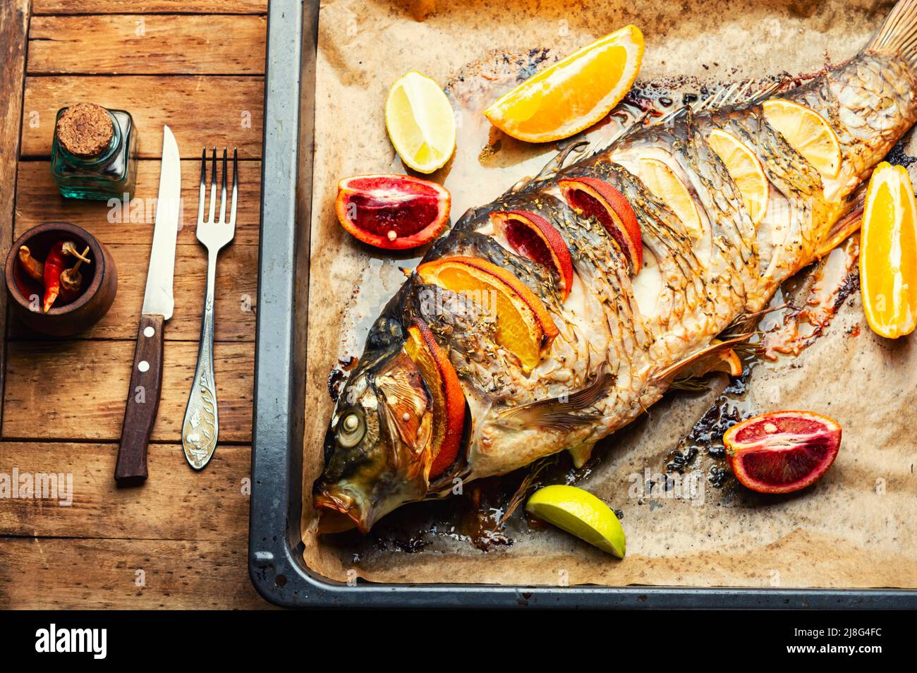 Large fish carp roasted whole with lemon and oranges Stock Photo Alamy