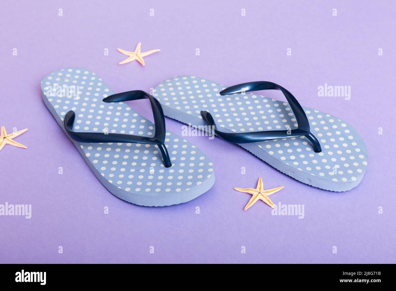 Beach accessories. Flip flops and starfish on colored background. Top ...