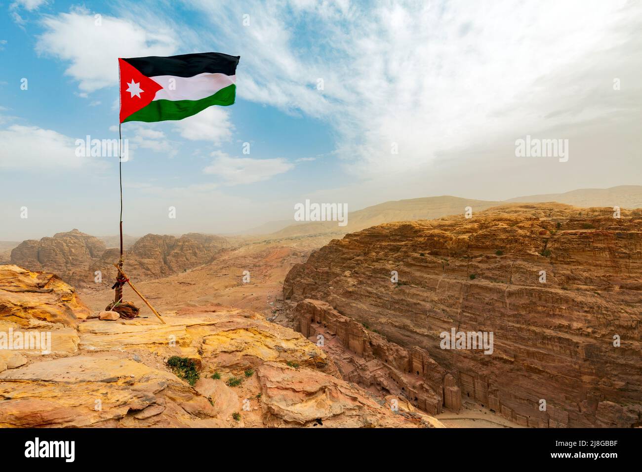 Jordan flag waving on a sunny and windy day in Petra landscape, Jordan Stock Photo