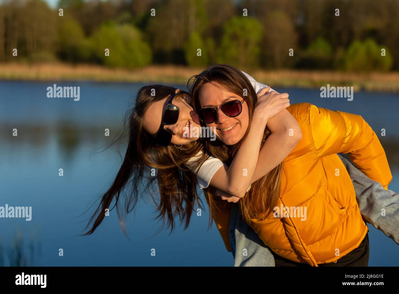 Man giving and adult woman a piggyback ride laughing and having fun in San  Diego, California. Stock Photo