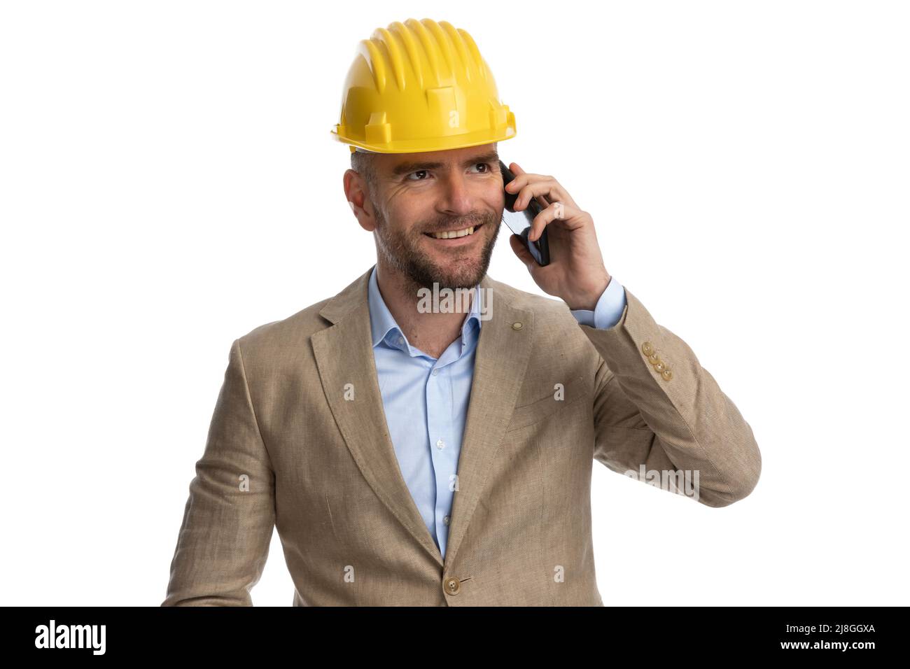 confident businessman in beige suit with undone shirt wearing helmet