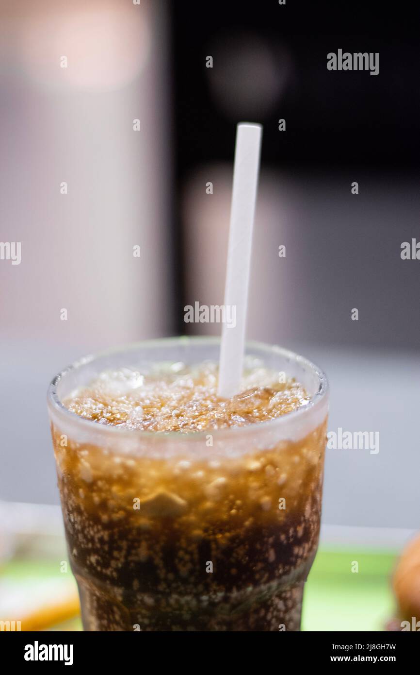 A close up picture of coke with ice and straw in a glass Stock Photo