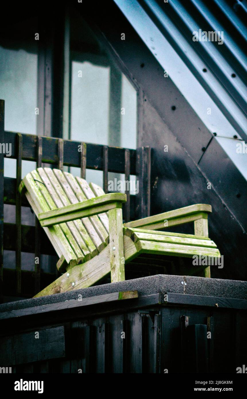 single wooden garden chair on roof of modernistic black wooden building