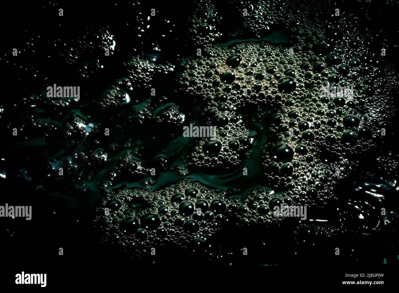 Black water surface with bubbles. Dark liquid background. Stock Photo