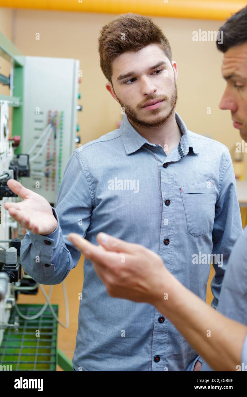 men talking next to control panel Stock Photo - Alamy