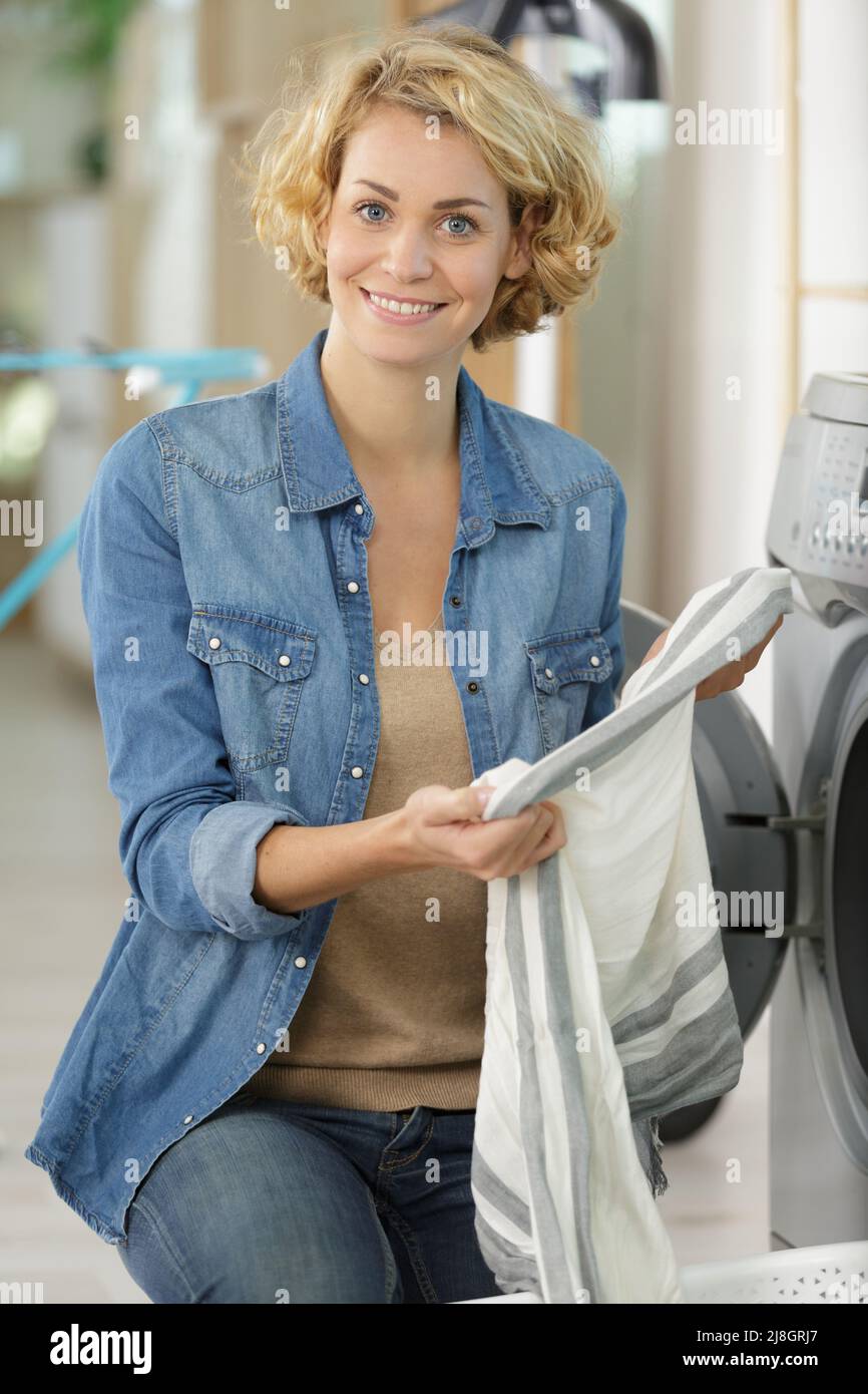 woman loading dirty clothes in washing machine for washing Stock Photo