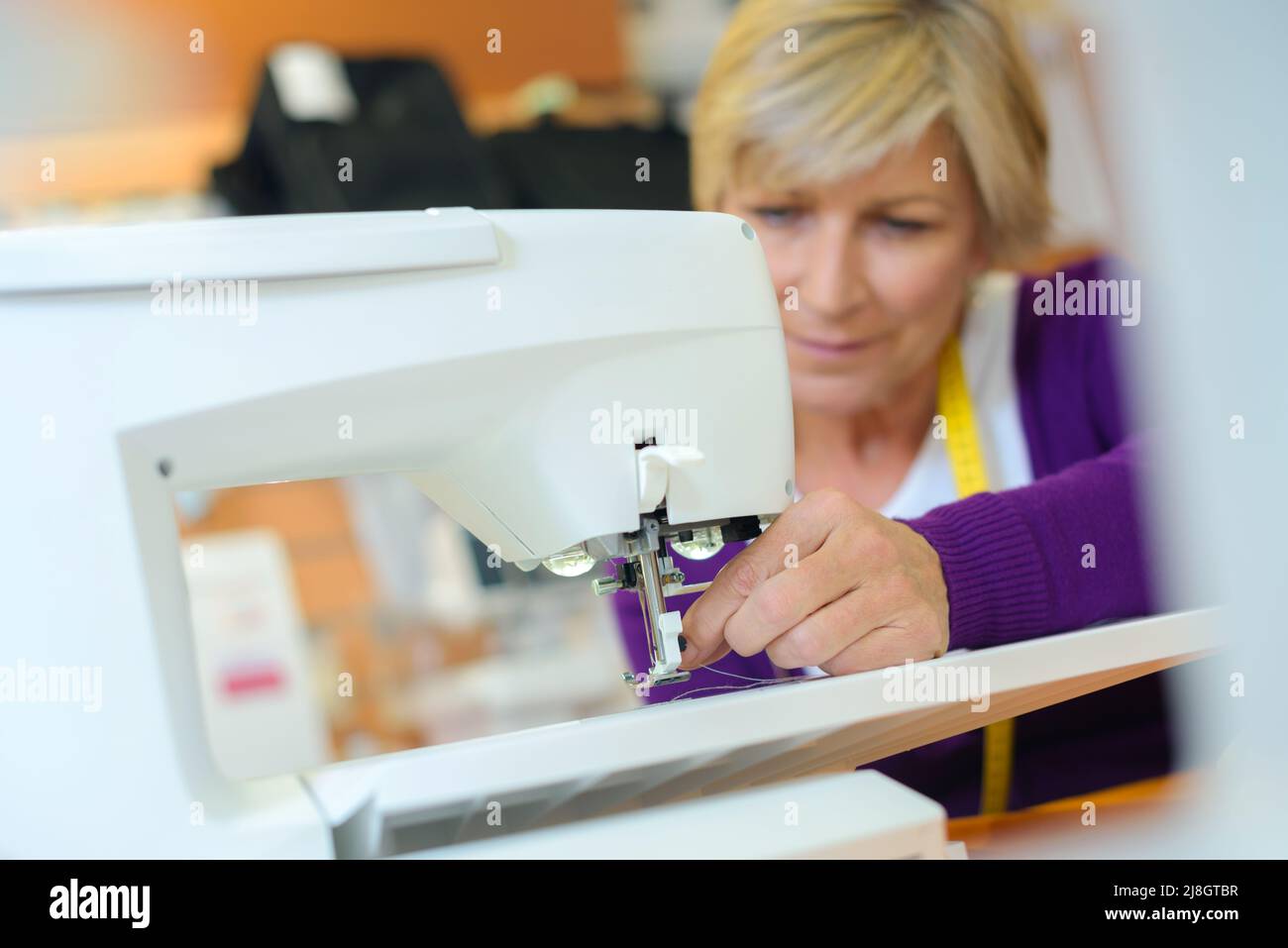 female tailor threading bobbin into sewing machine case Stock Photo Alamy