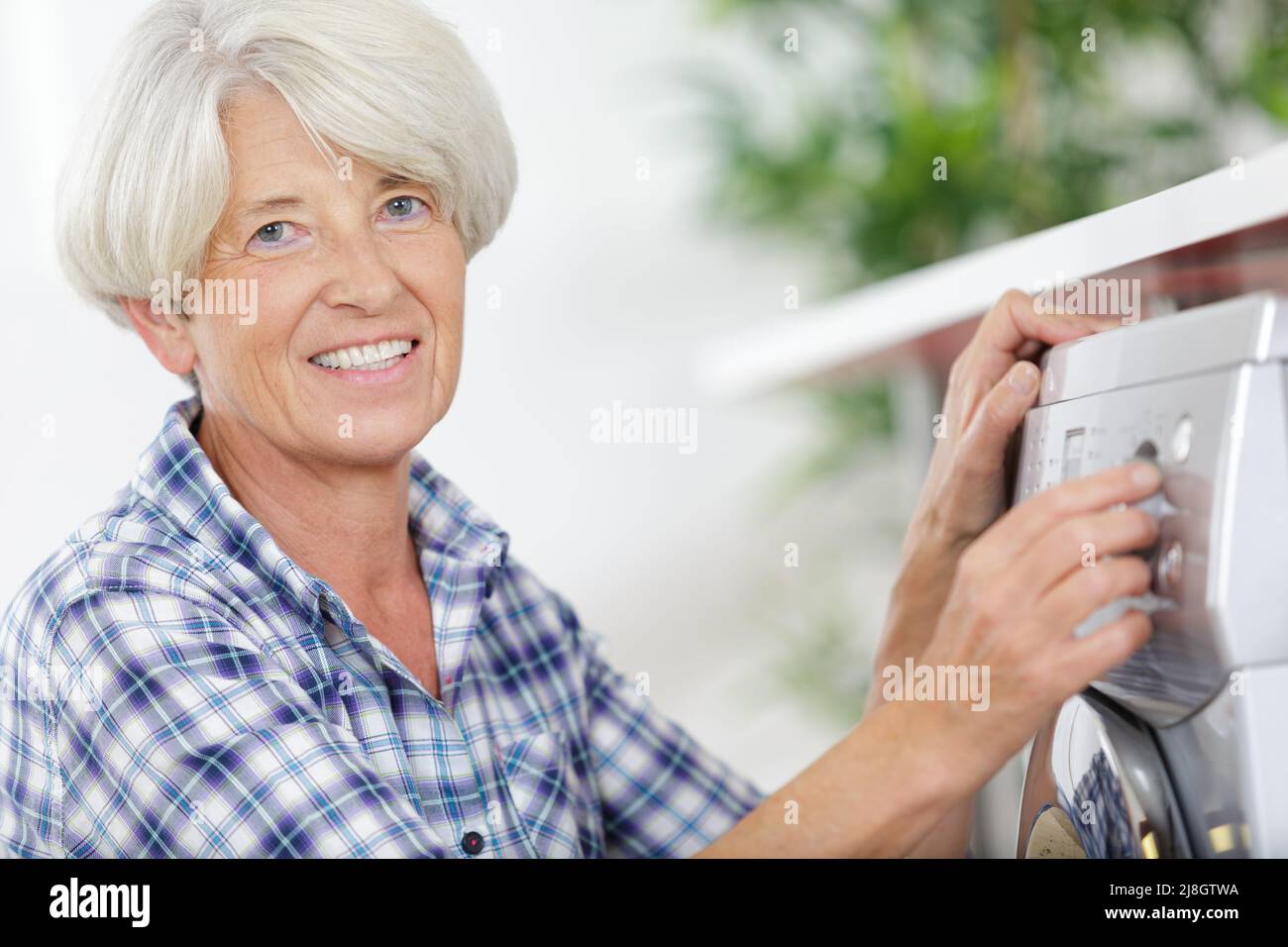 Mature woman washing machine hires stock photography and images Alamy