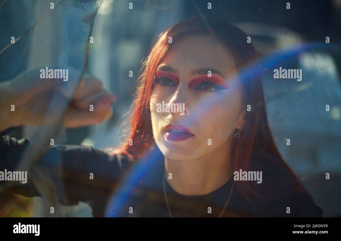 Excited woman indoors desperately looking through broken glass, danger and hopeless incident people in a trap Stock Photo