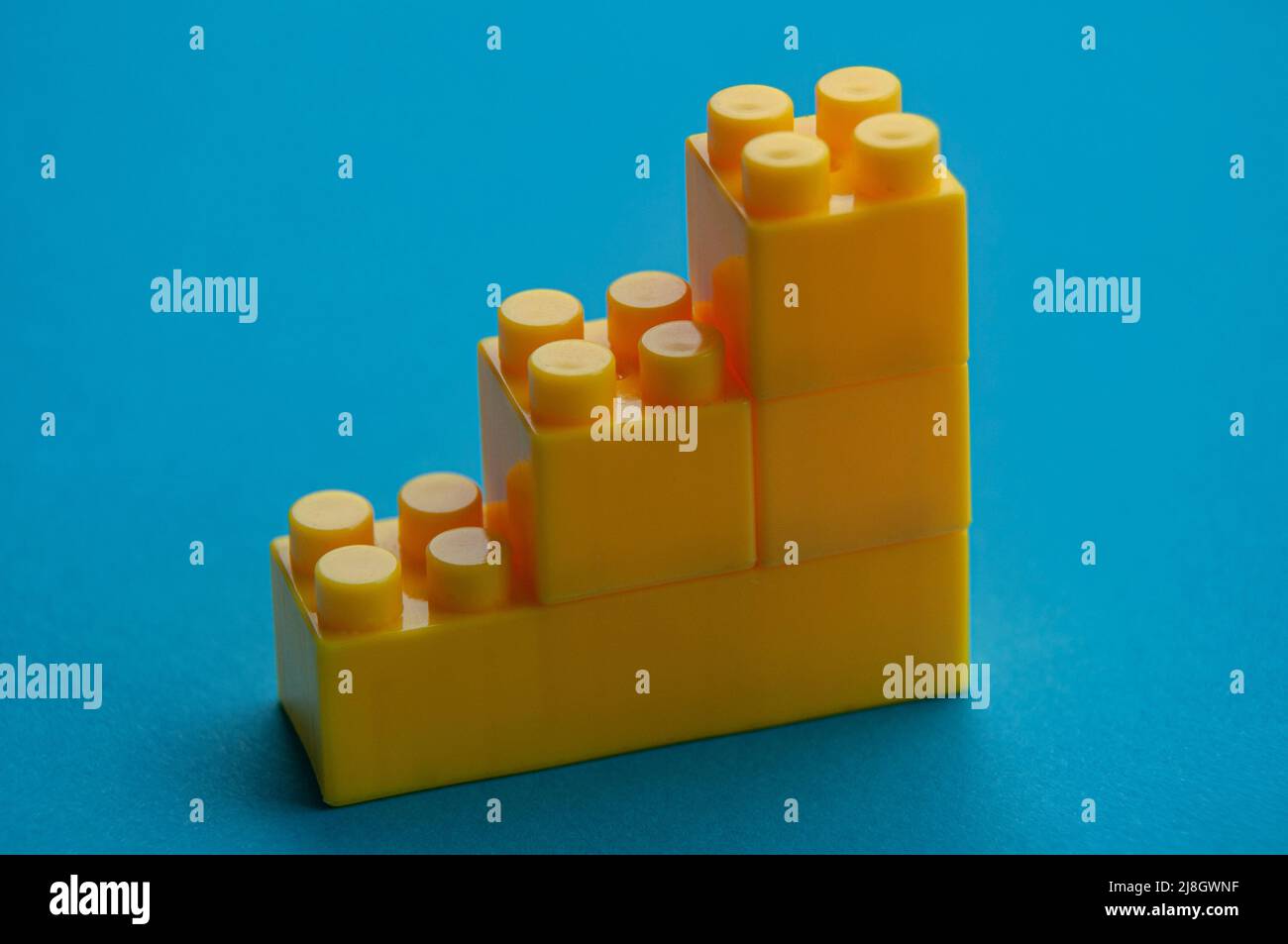 Plastic building blocks on blue background. Copy space Stock Photo - Alamy