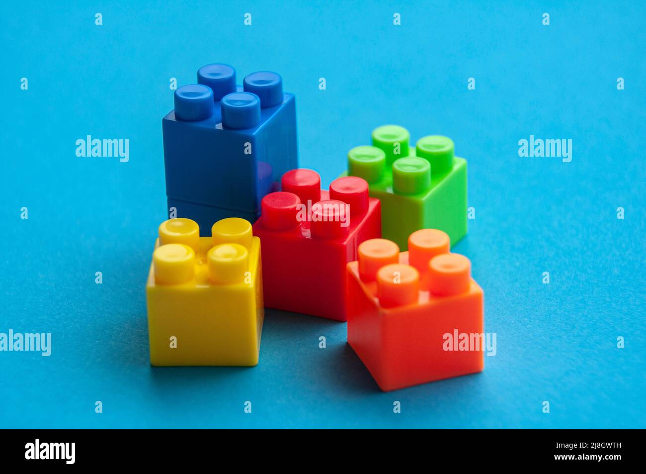 Plastic building blocks on blue background. Copy space Stock Photo - Alamy