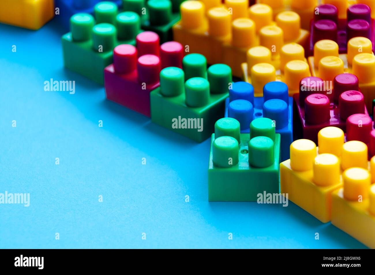Plastic building blocks on blue background. Copy space Stock Photo - Alamy