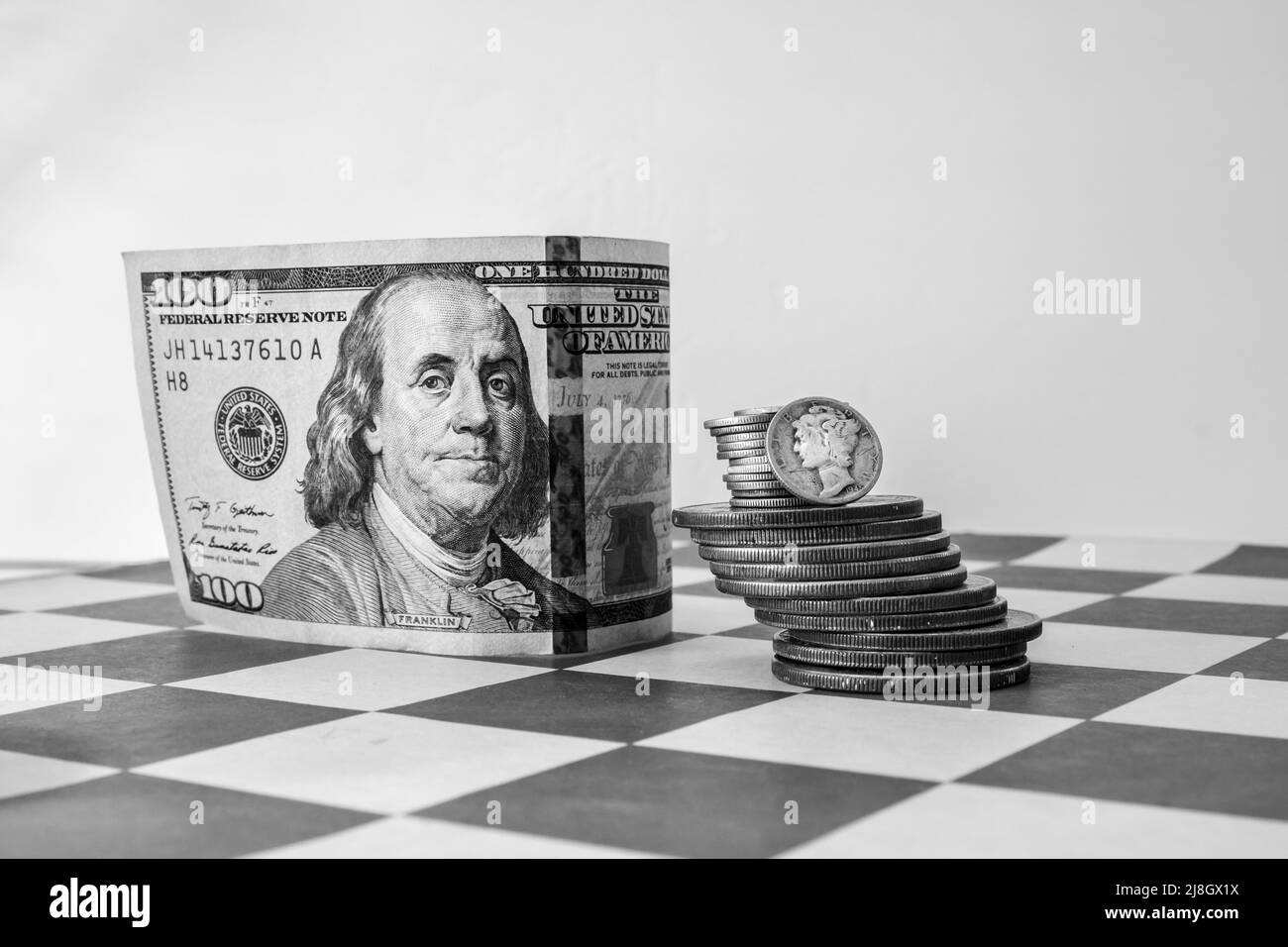 American Money, US Currency, 100 Dollar Bill, Stack of Silver Coins, Mercury Dime, on Chess Board Stock Photo