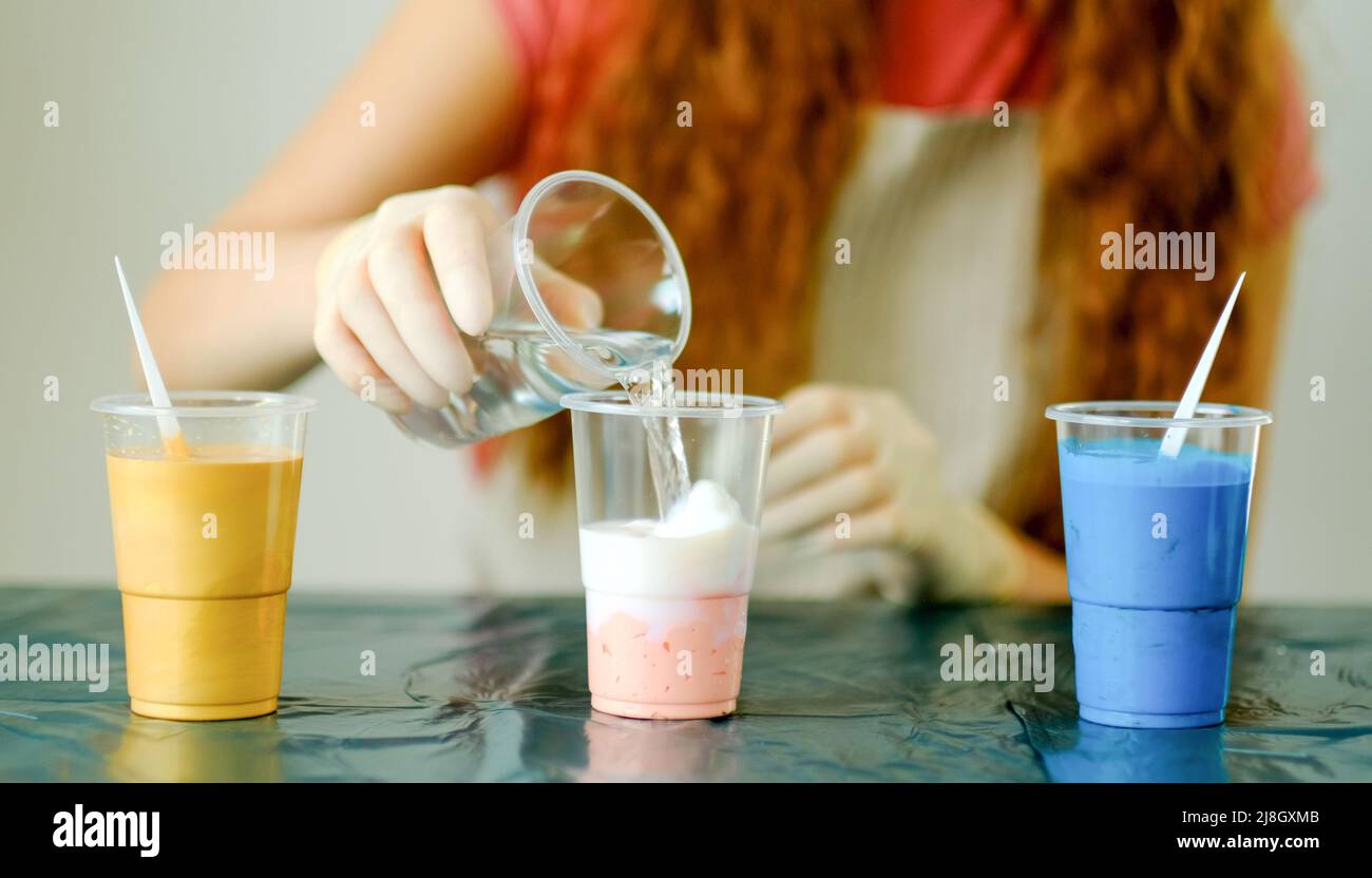 Fluid art technique. Female artist works on abstract fluid art painting