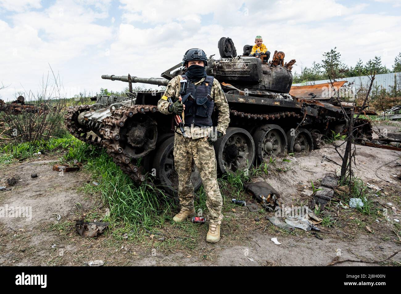 Nalyvaikivka, Ukraine. 15th May, 2022. A soldier (who refused to give his name due to issues of personal safety) who fought where this destroyed Russian tank is located posing with his son who is on the tank. Credit: SOPA Images Limited/Alamy Live News Stock Photo