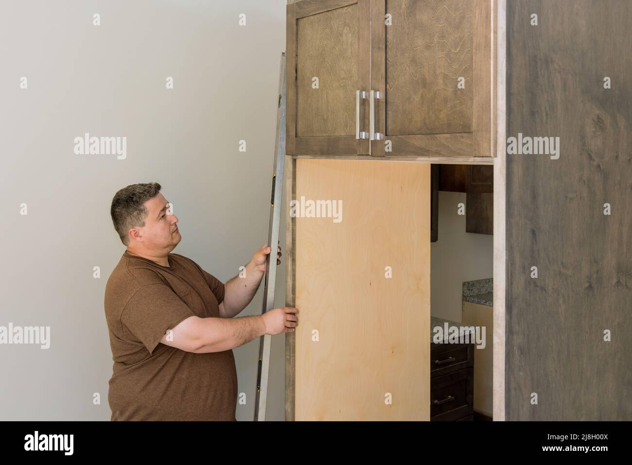 Worker hanging level the leveling kitchen Stock Photo Alamy