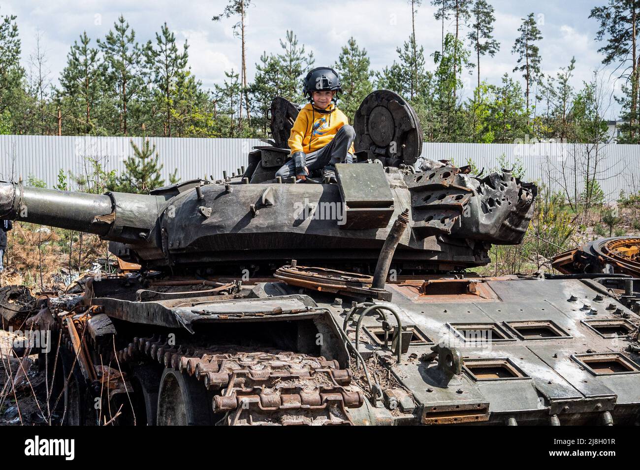Nalyvaikivka, Ukraine. 15th May, 2022. A child sitting on a destroyed Russian tank in Nalyvaikivka. Credit: SOPA Images Limited/Alamy Live News Stock Photo