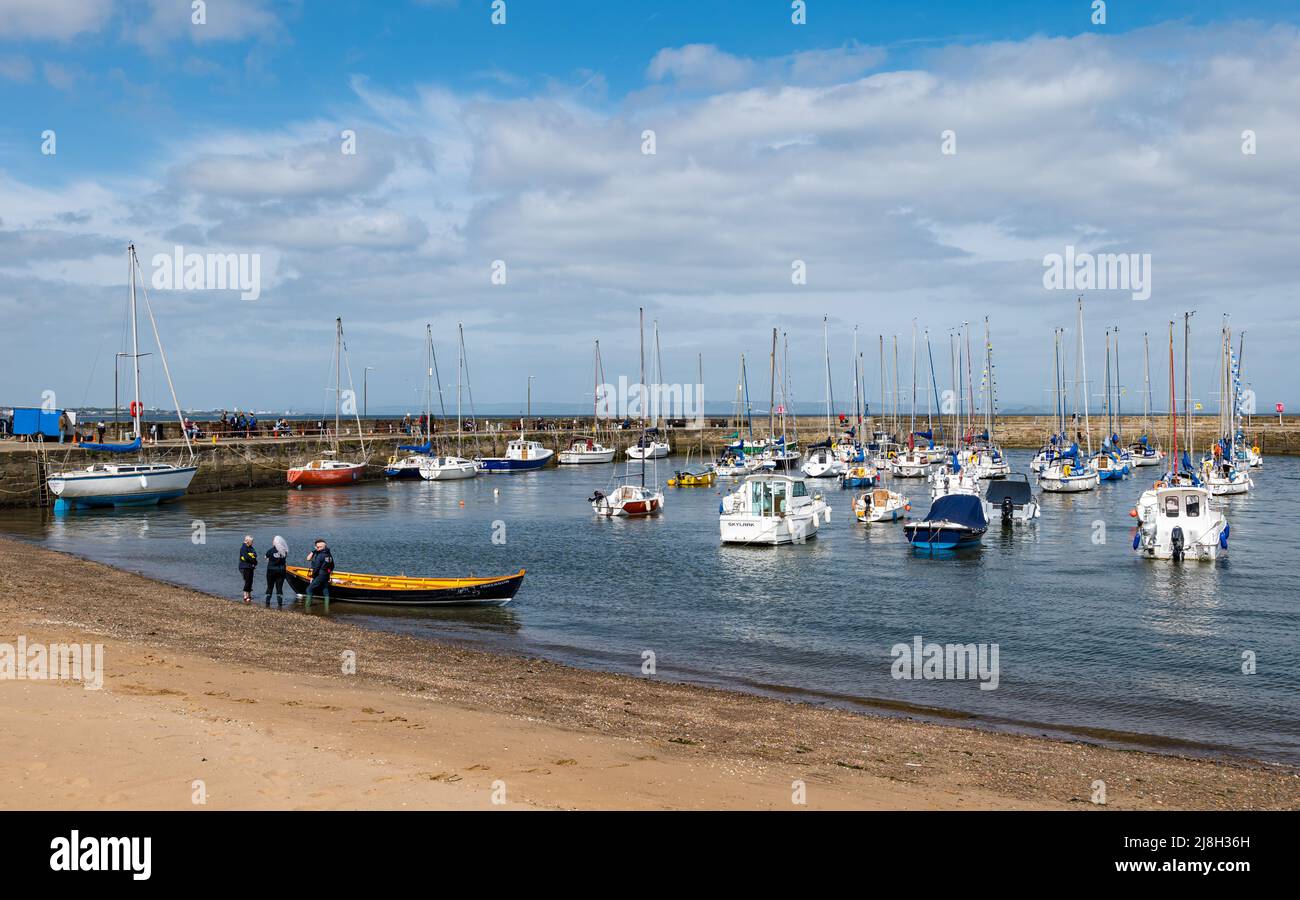 Sailing boats and coastal rowing boat being launched, Fisherrow Harbour, Musselburgh, East Lothian, Scotland, UK Stock Photo