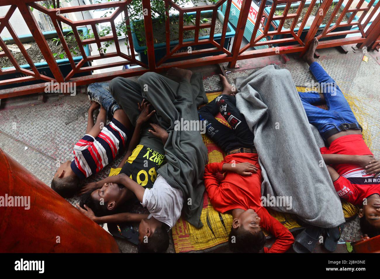 A group of homeless children sleeps on the foot over-bridge in Dhaka, Bangladesh, on May 16, 2022 Stock Photo