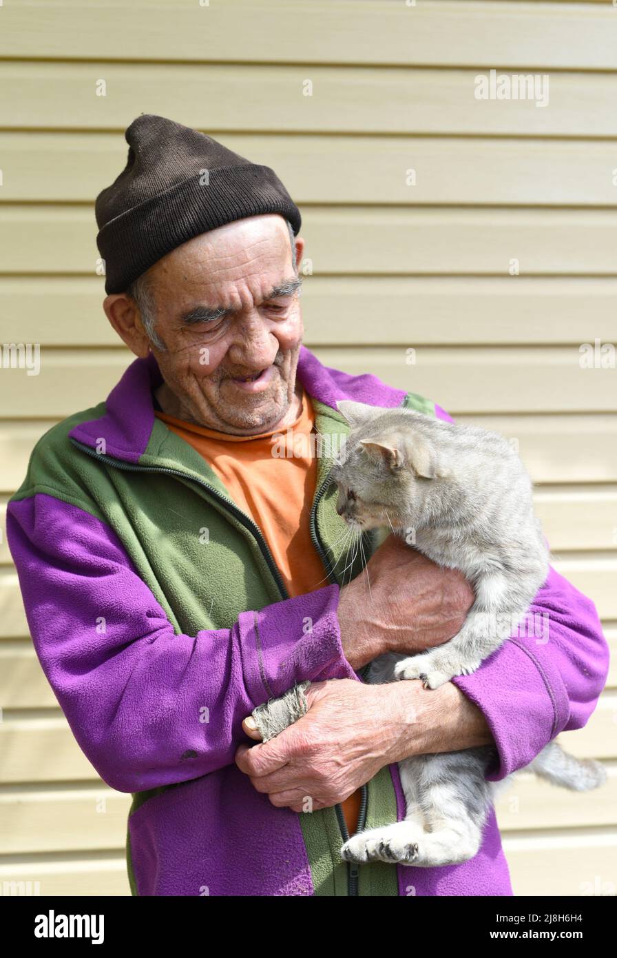 Old Russian man holding a cat and laughing Stock Photo Alamy