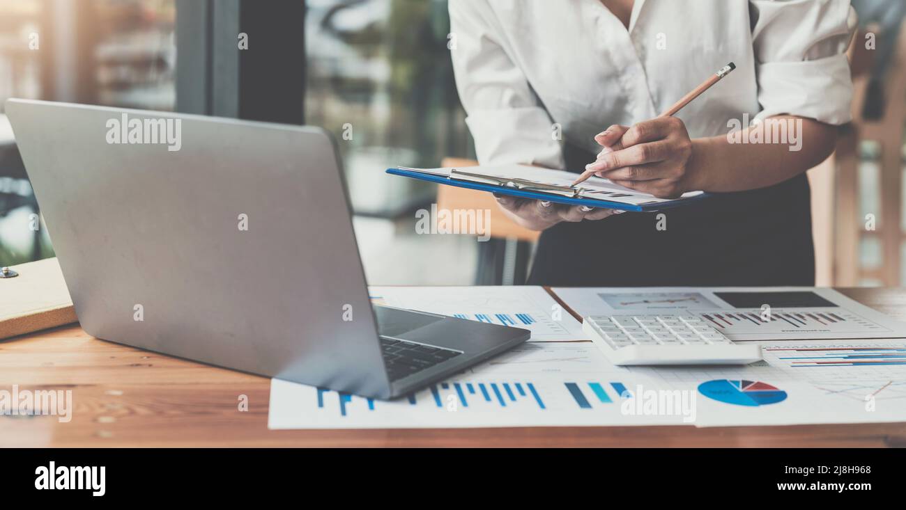 Businesswomen bookkeeper hand use calculator and laptop doing account ...