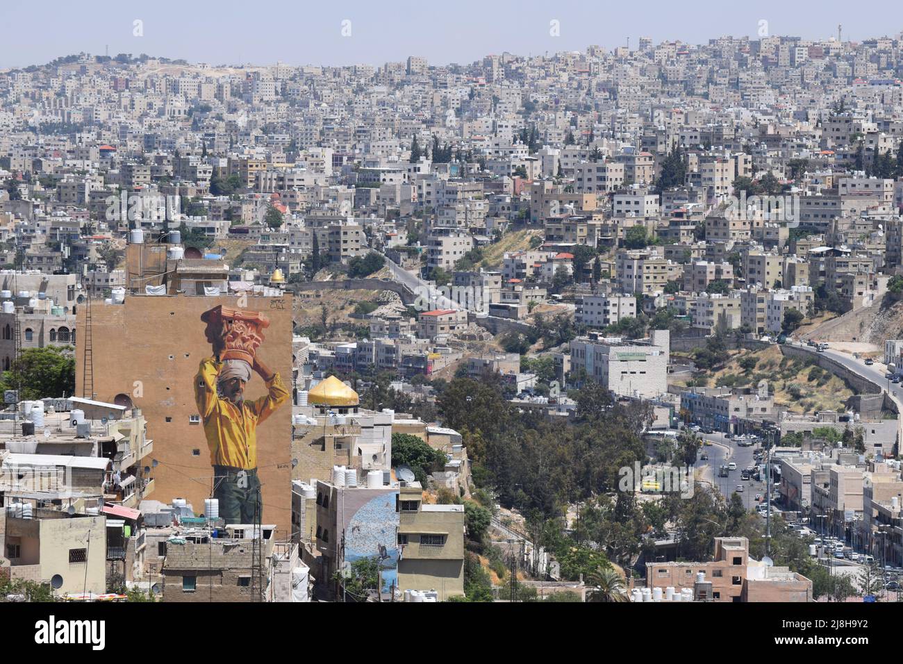 An aerial view of the city of Amman in Jordan with the huge 2021 mural called “The Column” visible on the left hand side of the scene Stock Photo