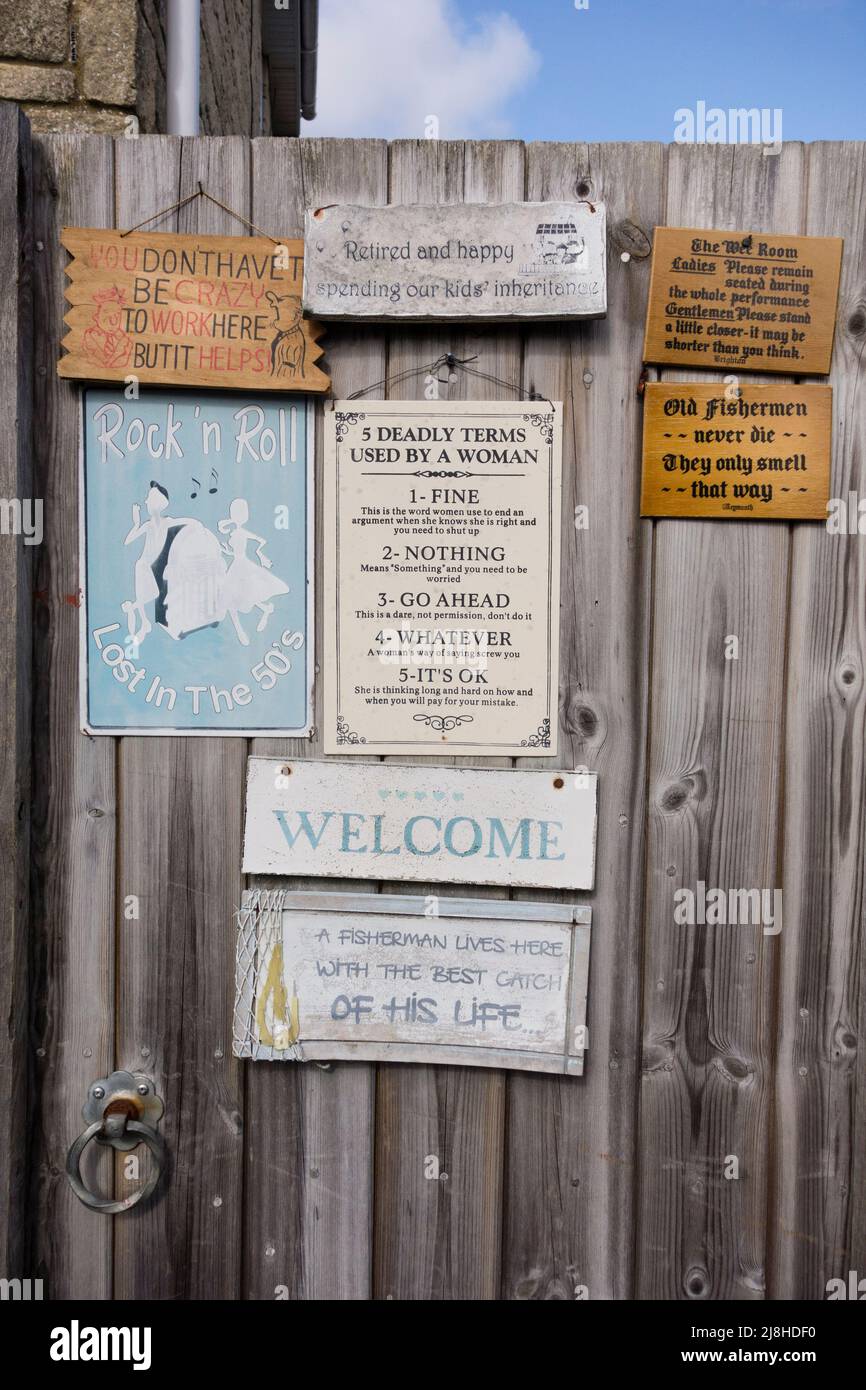 Wooden gate with humorous slogans, Gloucestershire, UK Stock Photo
