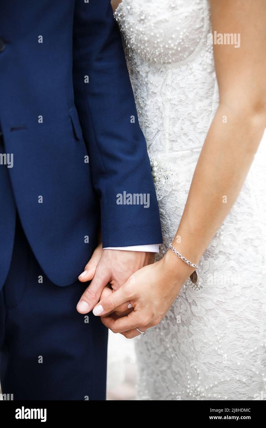 Bride and groom holding hands. Engagement ring on bride's finger Stock ...