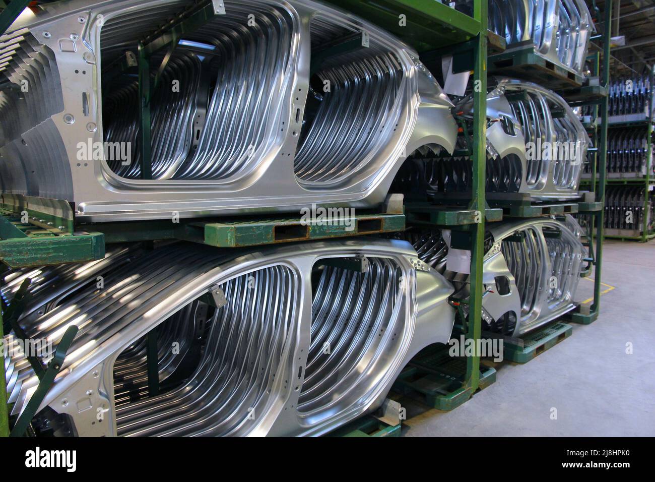 Car factory. Unfinished stainless steel car body parts warehouse. Car manufacturing plant in
