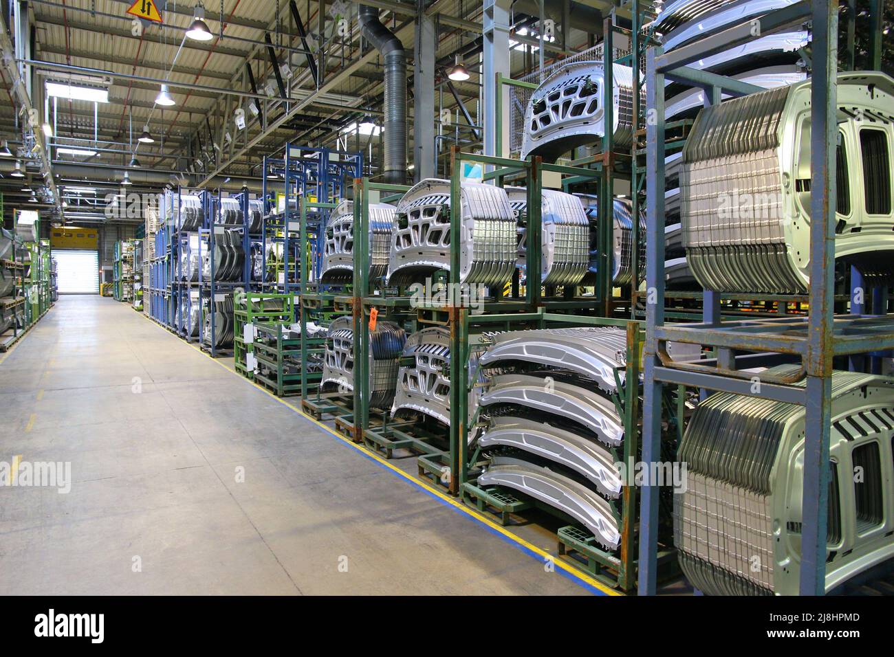 Car factory. Unfinished stainless steel car body parts warehouse. Car manufacturing plant in