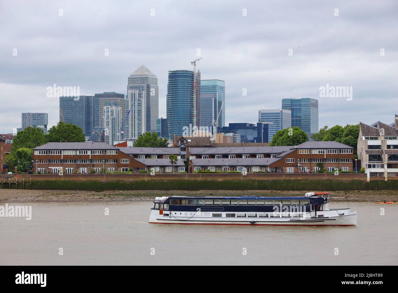 Canary Wharf and London Docklands seen from Greenwich district of London UK. Tour boat on river Thames. Stock Photo