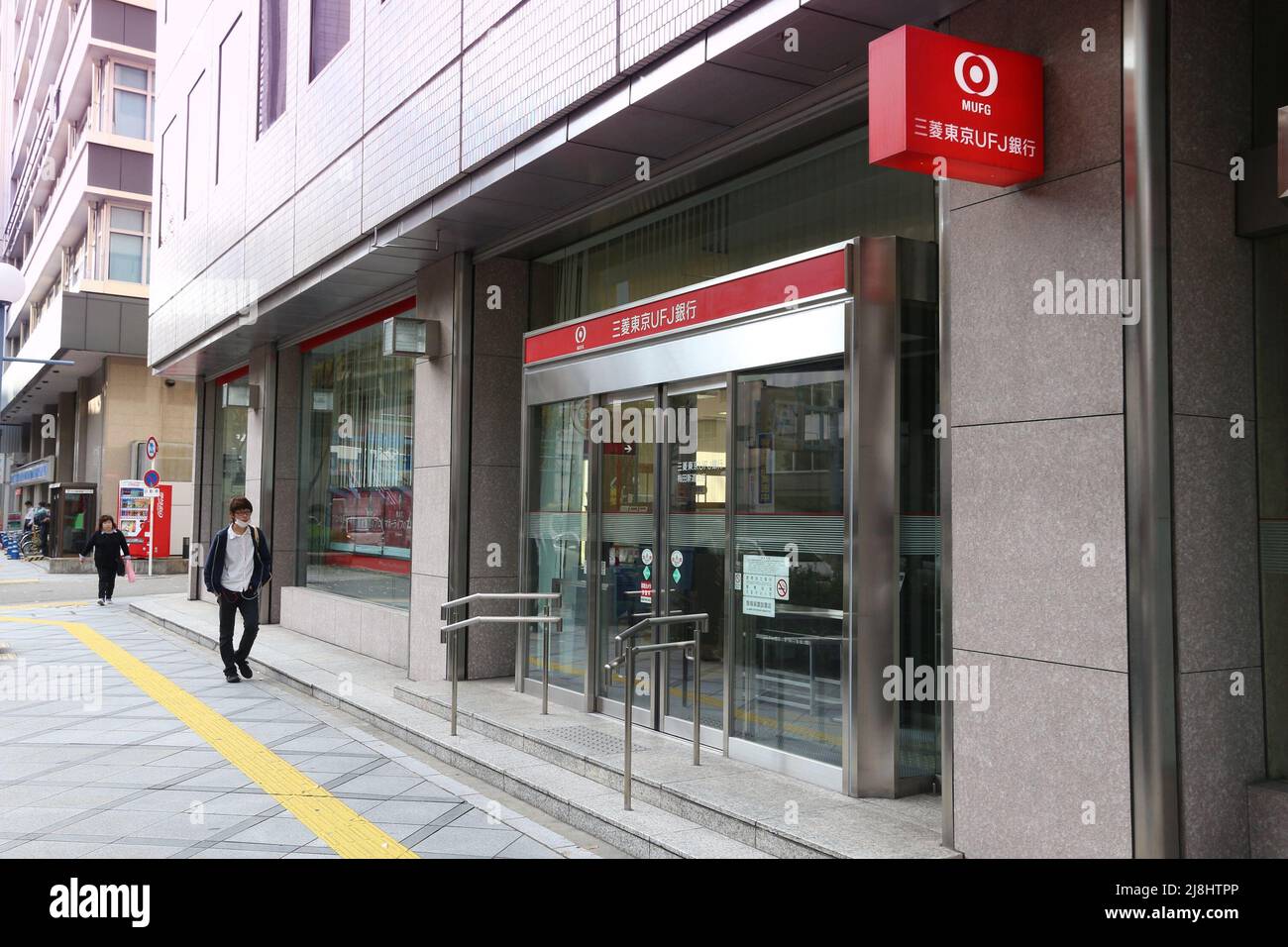 TOKYO, JAPAN - NOVEMBER 22, 2016: Person walks by MUFG Bank branch in Tokyo, Japan. MUFG full name is The Bank of Tokyo-Mitsubishi UFJ. It has 772 bra Stock Photo