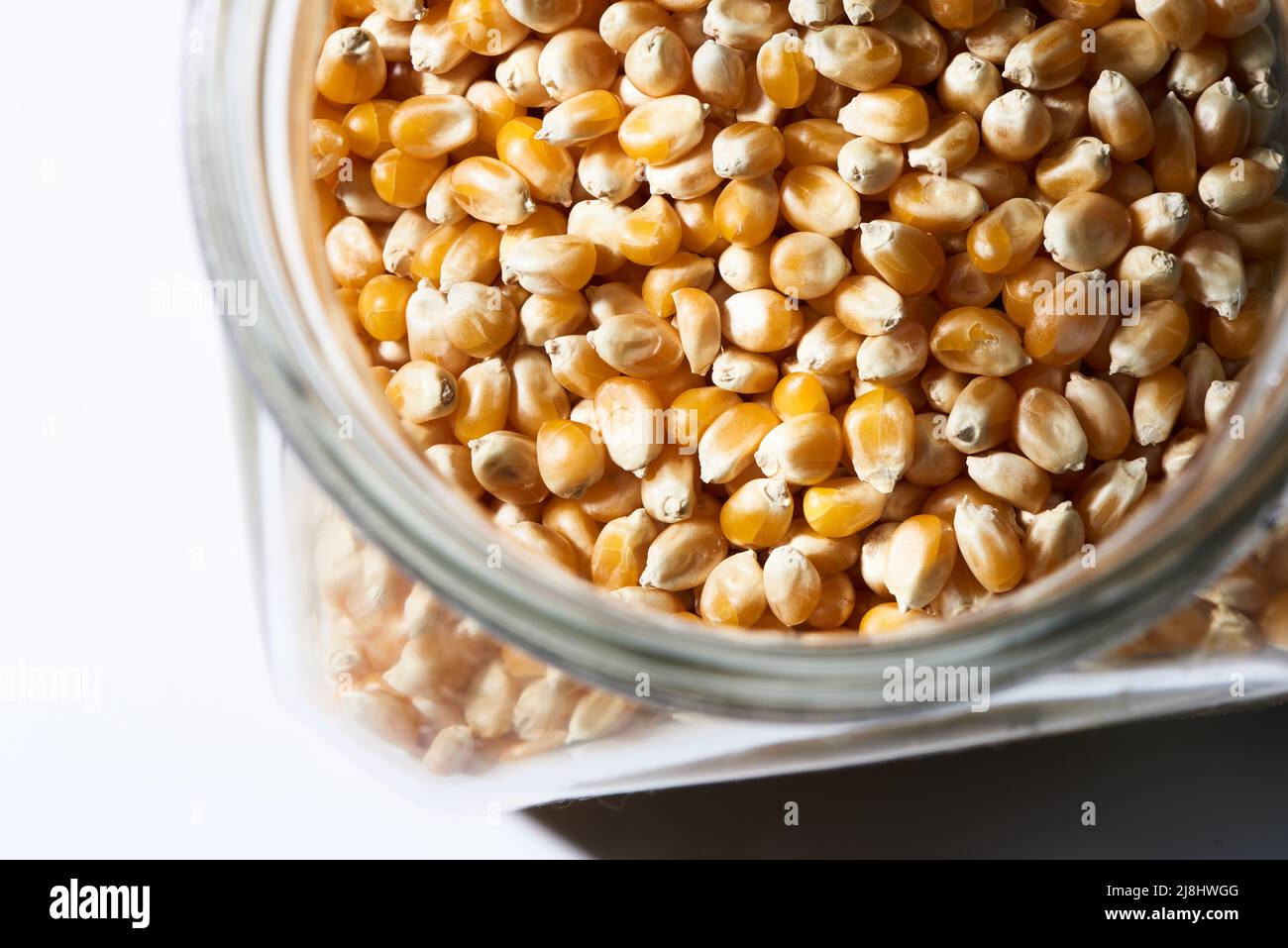 popcorn kernels in jar on white Stock Photo