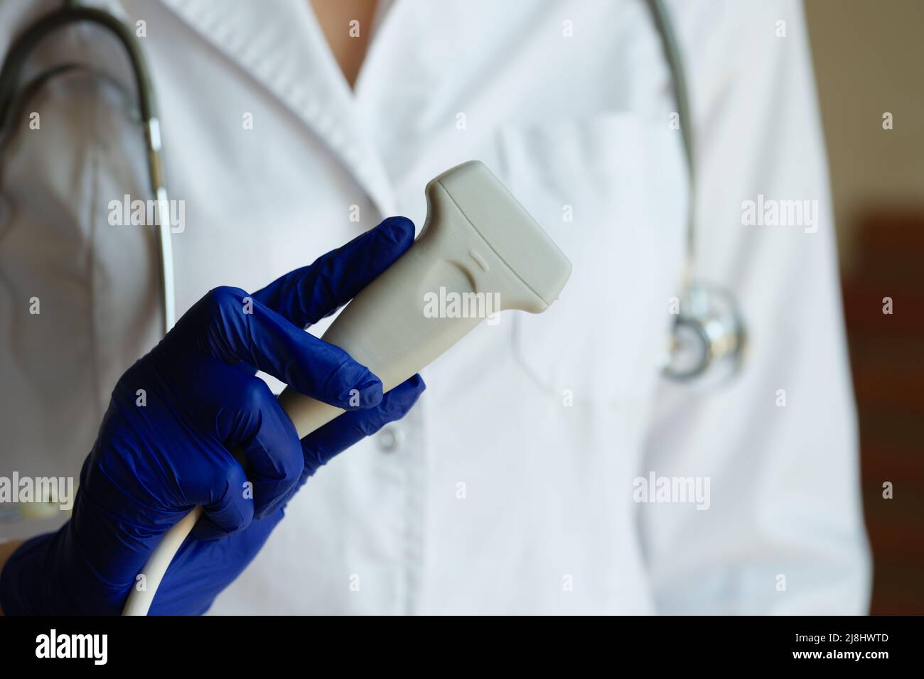 Doctor in white gown holding ultrasound probe Stock Photo